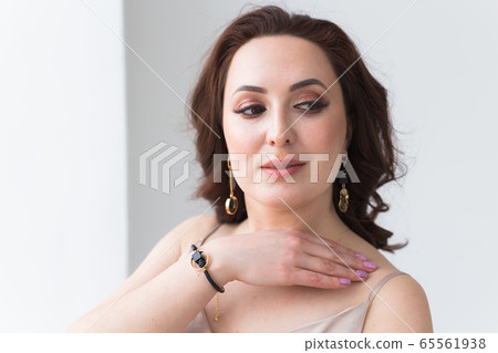 Close-up portrait of beautiful young woman with elegant hairstyle and luxurious jewelry and bijouterie. 65561938