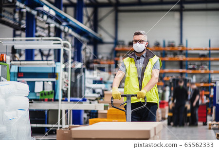 Man worker with protective mask working in industrial factory or warehouse. Man worker with protective mask working in industrial factory or warehouse. 65562333