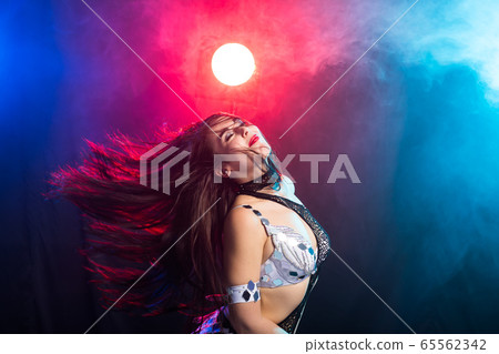 Young woman belly dancer in exotic dress with gold, dancing tribal fusion dance in studio. 65562342