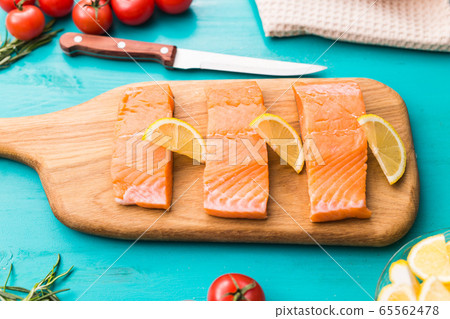 Fresh raw salmon on wooden cutting board. 65562478