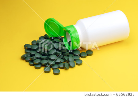 Close-up spirulina algae tablets. 65562923
