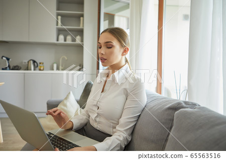 Attractive young businesswoman working on laptop Attractive young businesswoman working on laptop 65563516