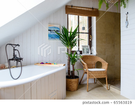 Potted plant and wicker chair in bathroom at home. 65563819