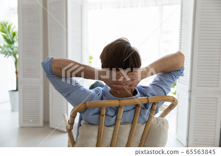 Back view of Caucasian man relax in chair at home 65563845