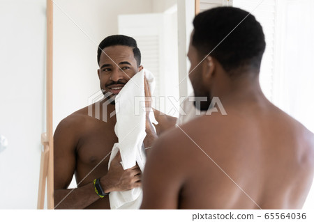 Young african american man do morning procedures in bathroom 65564036