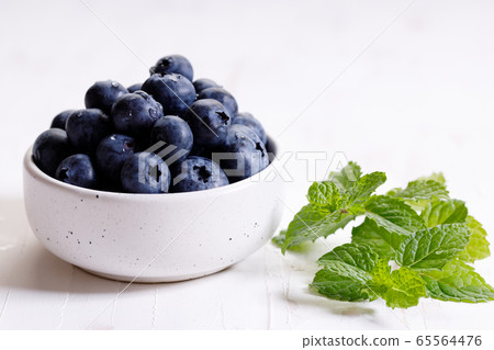 fresh blueberries in ceramics bowl with mint 65564476