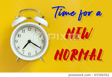 the new normal after COVID-19 Coronavirus pandemic concept. white alarm clock isolated on yellow background with text time for a new normal. a previously unfamiliar situation that has become standard 65566562