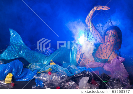 Ocean pollution, rubbish in the water. Sad fairytale mermaid in dirty ocean. Plastic trash and garbage in water. Environmental problem, plastic bag and bottles polluting planet. Ocean pollution, rubbish in the water. Sad fairytale mermaid in dirty ocean. Plastic trash and garbage in water. Environmental problem, plastic bag and bottles polluting planet. 65568577