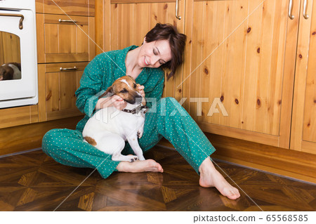 Young beautiful woman at home with her cute dog. Quarantine, isolation, coronavirus pandemic world. Stay at home. Young beautiful woman at home with her cute dog. Quarantine, isolation, coronavirus pandemic world. Stay at home. 65568585