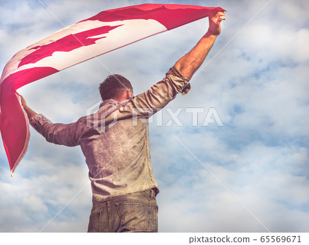 Attractive man holding Canadian Flag. National Attractive man holding Canadian Flag. National 65569671