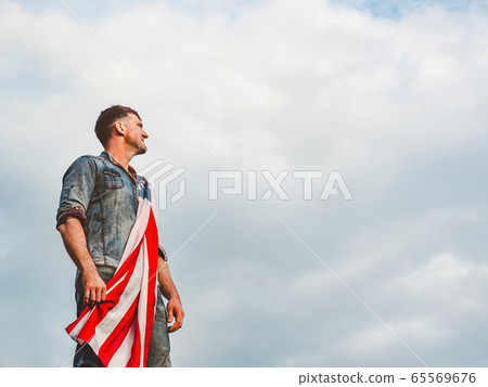 Attractive man holding Flag of the United States Attractive man holding Flag of the United States 65569676