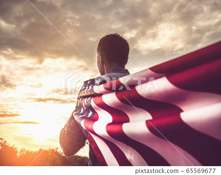 Attractive man holding Flag of the United States Attractive man holding Flag of the United States 65569677
