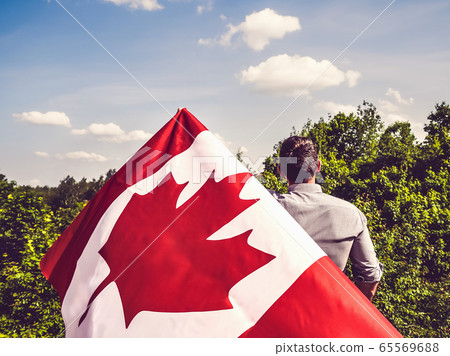 Attractive man holding Canadian Flag. National 65569688