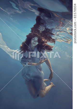 Portrait of a girl in a blue dress under water 65570934
