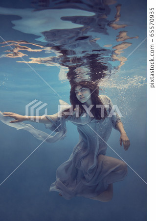 Portrait of a girl in a blue dress under water 65570935