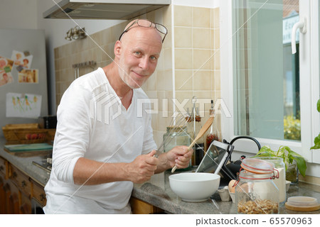 mature man smiling in the kitchen mature man smiling in the kitchen 65570963