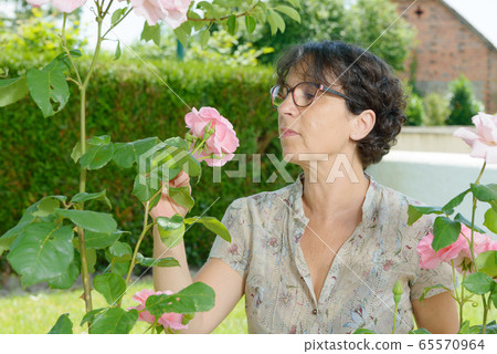 middle-aged woman with glasses in the garden 65570964