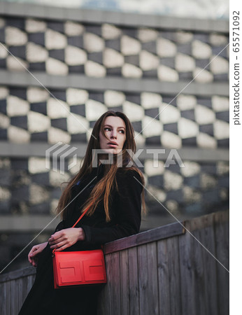 Elegant young woman in coat 65571092