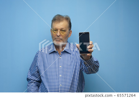 Elderly man in yellow glasses call on the phone Elderly man in yellow glasses call on the phone 65571264