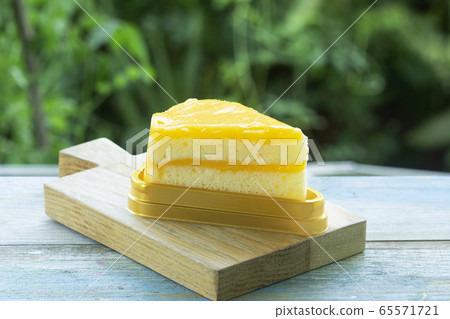 Orange cake on wood plate 65571721