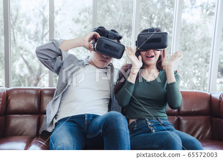 Young Couple Having Fun Exciting While Watching Video Via Virtual Reality Together Young Couple Having Fun Exciting While Watching Video Via Virtual Reality Together 65572003