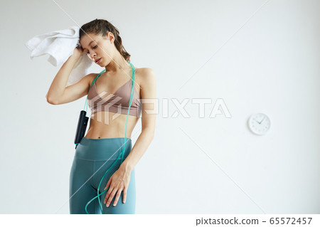 Exhausted Young Woman Holding Jumping Rope 65572457