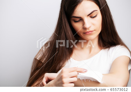 Young woman doing hair removal at home in the hands area 65573012