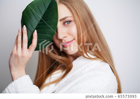 Natural cosmetics, beautiful woman face in green leaves. 65573093