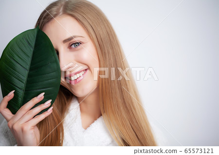 Natural cosmetics, beautiful woman face in green leaves. 65573121