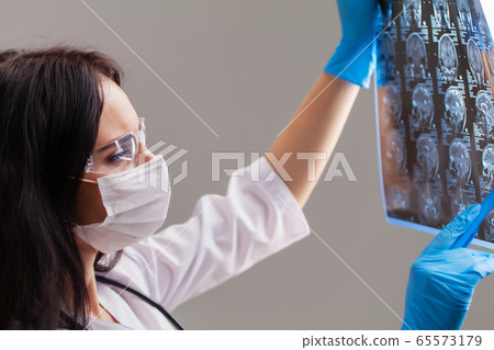 Doctor examines an MRI image of the patient's brain Doctor examines an MRI image of the patient's brain 65573179