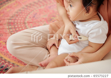 Mother checking temperature of child 65573227