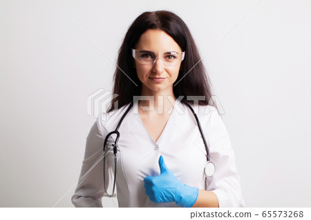 Doctor with protective goggles and stethoscope on her workspace Doctor with protective goggles and stethoscope on her workspace 65573268