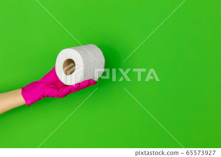 Hand in pink rubber glove with toilet paper isolated on green studio background with copyspace. 65573927