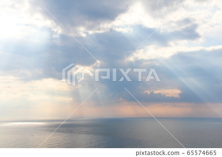 Light rays through the clouds over sea Light rays through the clouds over sea 65574665