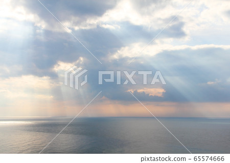 Light rays through the clouds over sea Light rays through the clouds over sea 65574666
