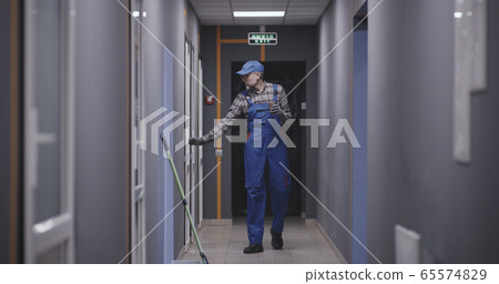Janitor checking rooms in building 65574829