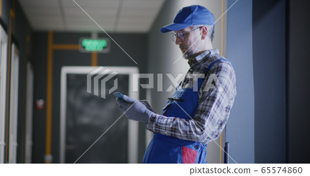 Janitor using a smartphone 65574860