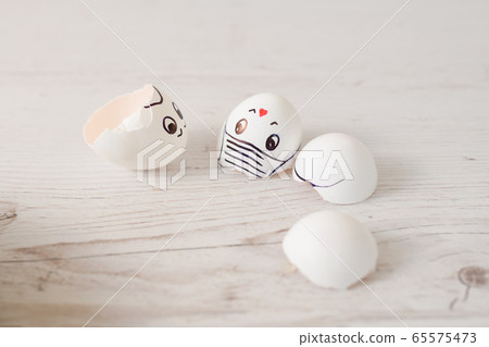 Broken white egg shells with painted faces 65575473