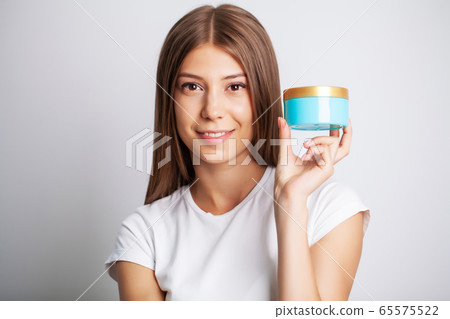 Woman Face Skin Cosmetics, pretty woman hold in hand facial cream 65575522
