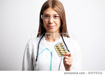 Doctor holds in his hands the prescribed pills for patient Doctor holds in his hands the prescribed pills for patient 65575532