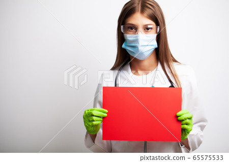 Doctor in a gloves, mask and glasses holds a blank form with space for text Doctor in a gloves, mask and glasses holds a blank form with space for text 65575533