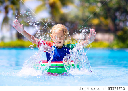 Child in swimming pool on toy ring. Kids swim. Child in swimming pool on toy ring. Kids swim. 65575720