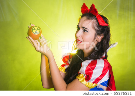 Woman holding hazardous radioactive apple. Nuclear and radiation measurement concept. 65576551