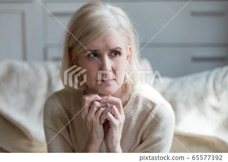 Thoughtful upset mature lady crying thinking of loneliness or gr Thoughtful upset mature lady crying thinking of loneliness or gr 65577392