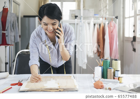Young tailor design owner woman talking with 65577488
