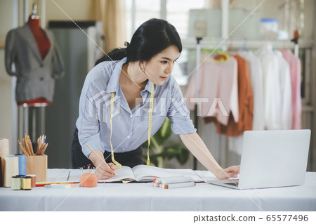 Designer using computer and drawing sketches for Designer using computer and drawing sketches for 65577496