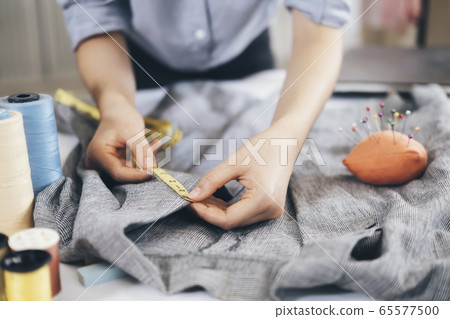 The tailor taking measurements of jacket The tailor taking measurements of jacket 65577500