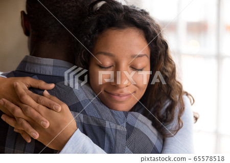 Happy african american wife hugging husband holding tight feelin 65578518