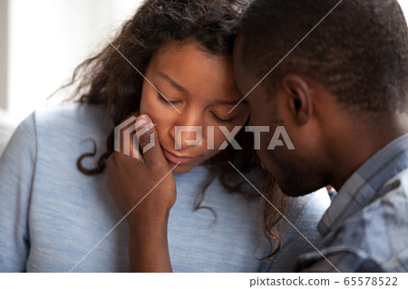 Loving african american husband apologizing comforting sad upset 65578522