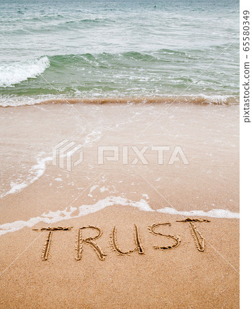 Word trust written on the sand 65580349